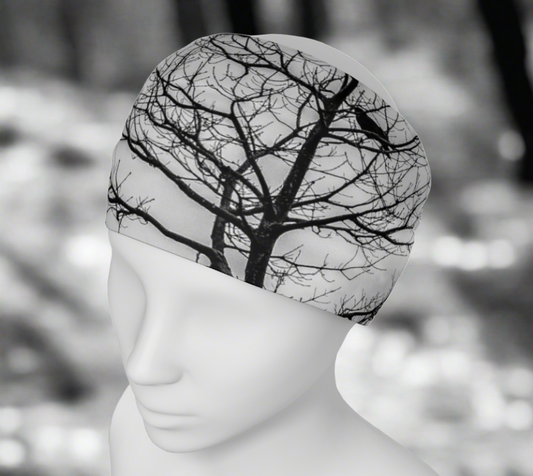 headband neck gaiter with a image of a tree with several crows in it. Black and white.