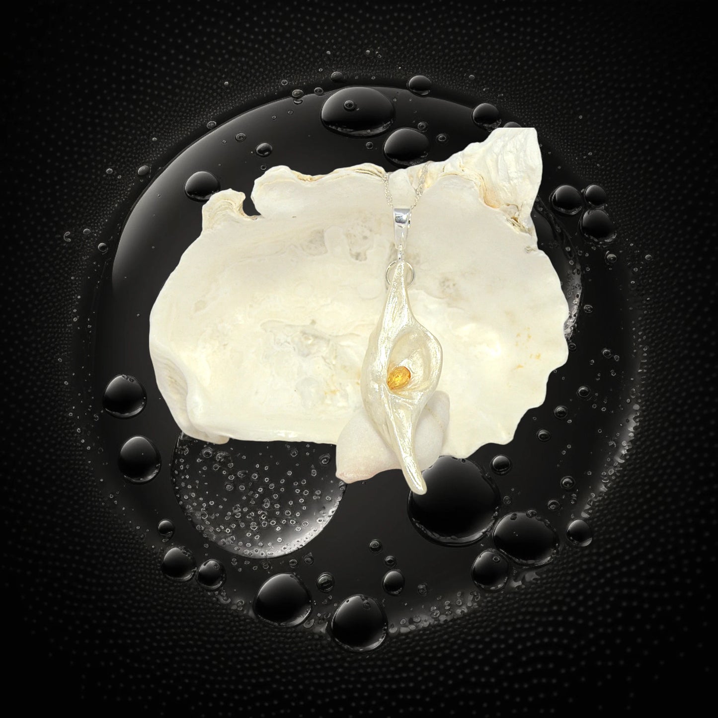 Lightmaker natural seashell pendant A beautiful pear shaped rose cut Citrine compliments the pendant. The pendant is displayed in front of a larger seashell.  the background is black water bubbles.
