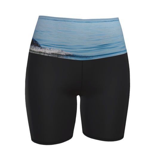 Orca Spray yoga shorts features a image of an orca exhaling on the ocean. This image is printed on the waistband and the rest of the shorts is black.