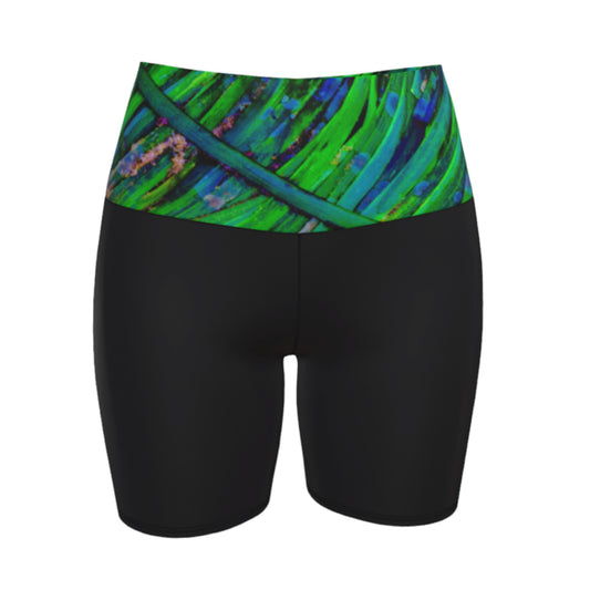 Shades of green yoga shorts features the image of spring green ocean sea grass at low tide. the rest of the shorts are black.