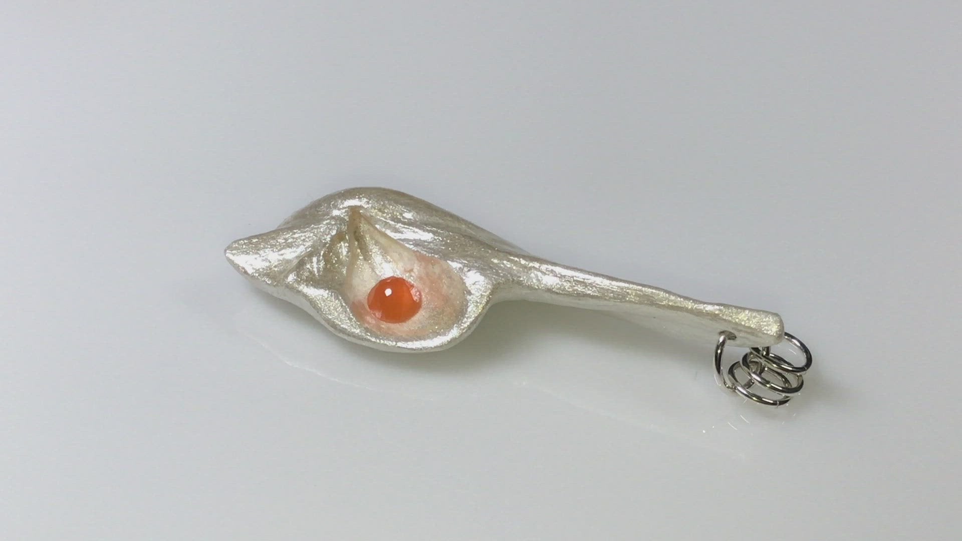 A video showcasing Tequila Sunrise natural seashell pendant a rose cut Carnelian gemstone.